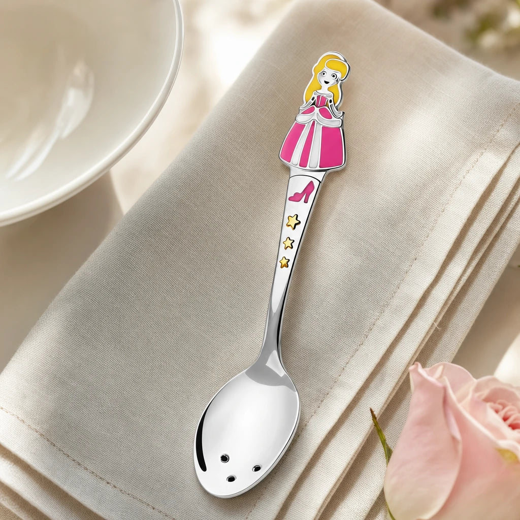 Babylöffel aus 925 Silber mit Prinzessinnen-Figur in Emaille auf einer Leinenserviette neben einer Porzellanschale — Lifestyle