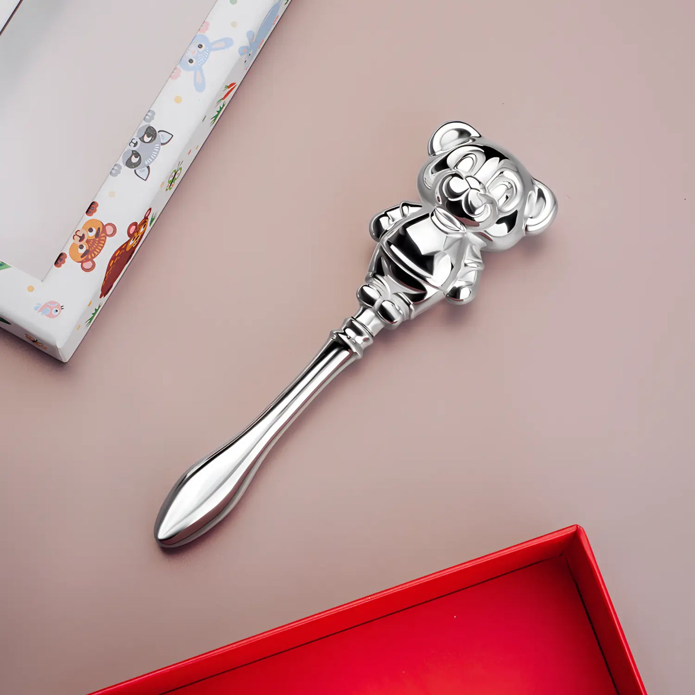 Seitenansicht der Babyrassel aus 999 Vollsilber mit Teddybär-Motiv – edles Geschenk zur Geburt oder Taufe.