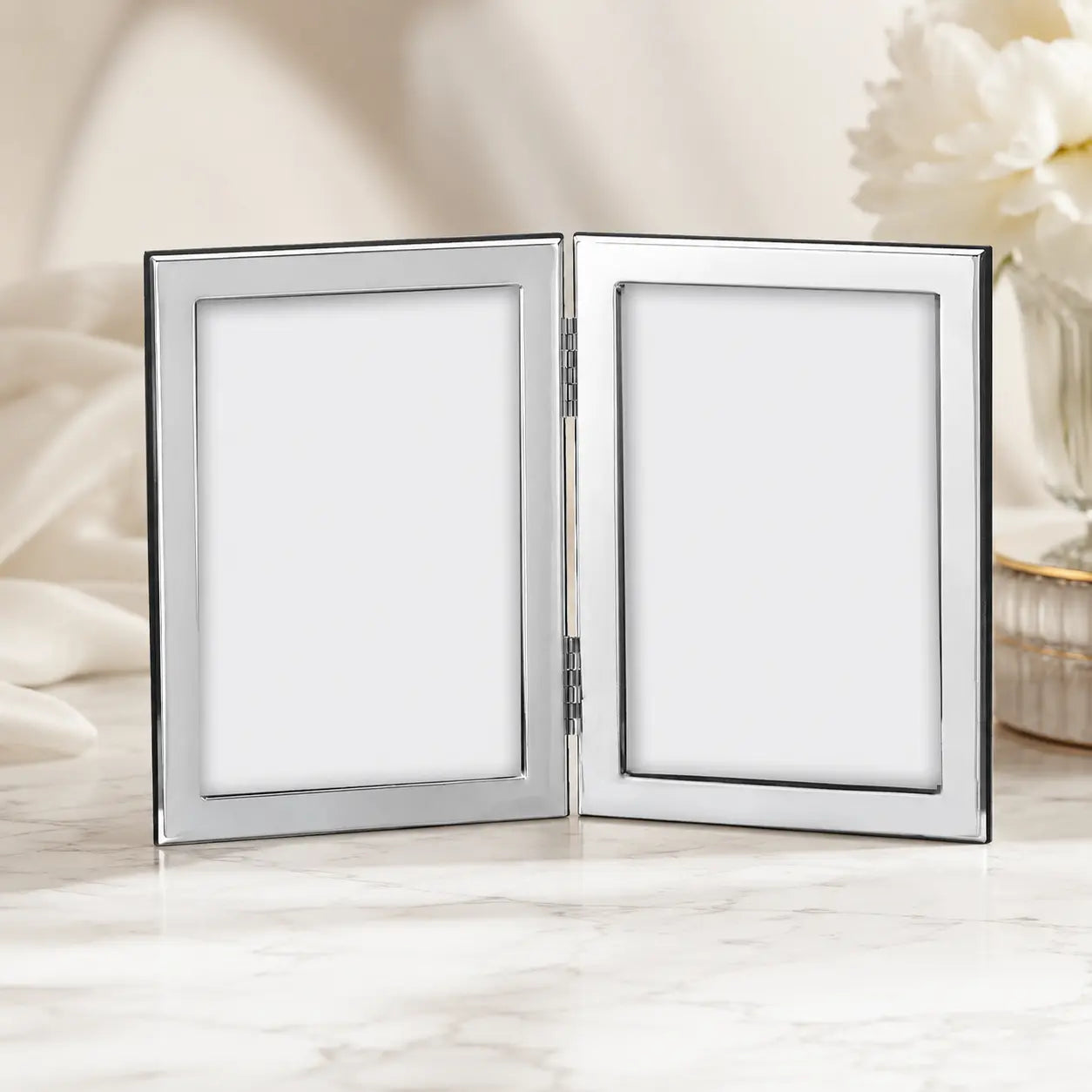 Doppel-Bilderrahmen aus 925 Silber für zwei Fotos im Format 13 × 18 cm in elegantem Studio-Lifestyle-Ambiente.