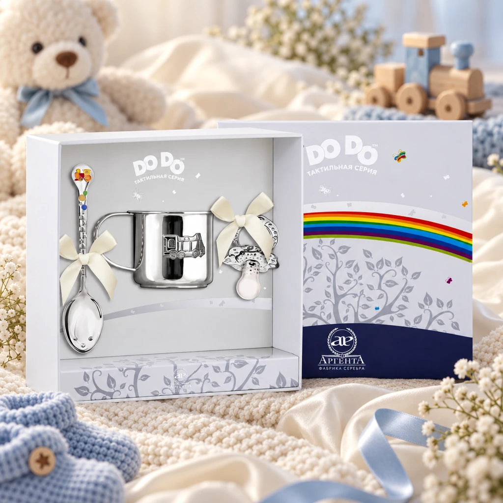 Geschenkset DoDo 925 Silber Dampflok — Schnuller, Becher, Löffel in der Original-Geschenkbox — Lifestyle-Aufnahme auf cremefarbenem Satin mit Plüschtier und Schleierkraut, Geschenk zur Geburt