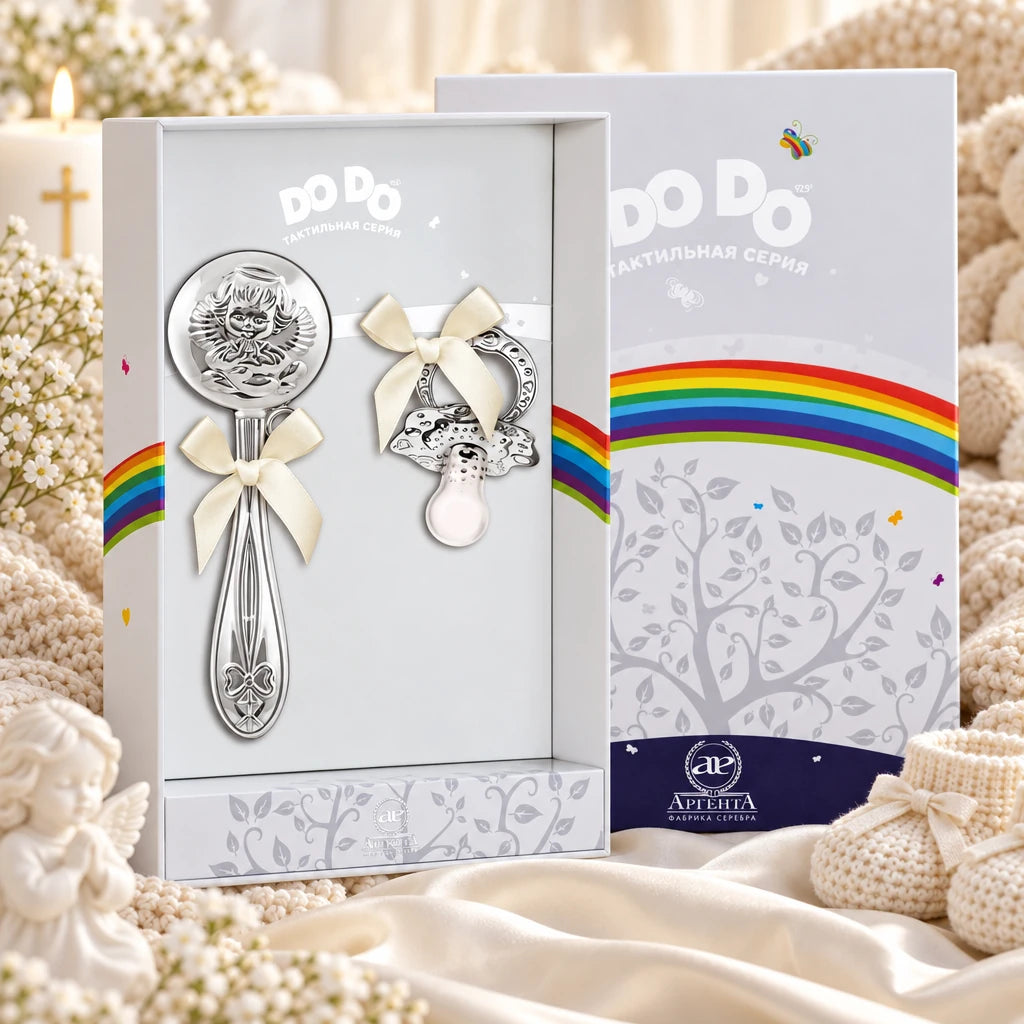 Geschenkset für Babys mit Babyrassel Engel in der Original-Geschenkbox — Lifestyle-Aufnahme auf cremefarbenem Satin mit Plüschtier und Schleierkraut, Geschenk zur Geburt