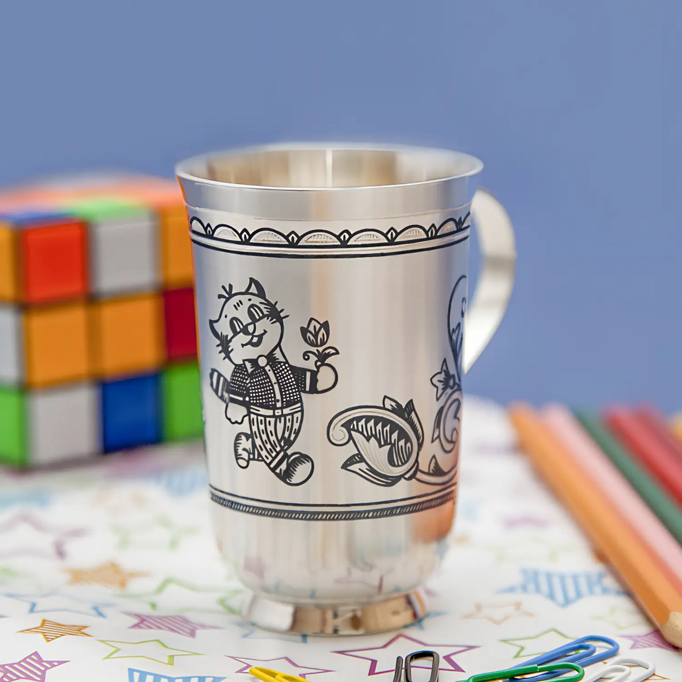 Kinderbecher aus 925 Silber mit Niello-Katermotiv und buntem Hintergrund.