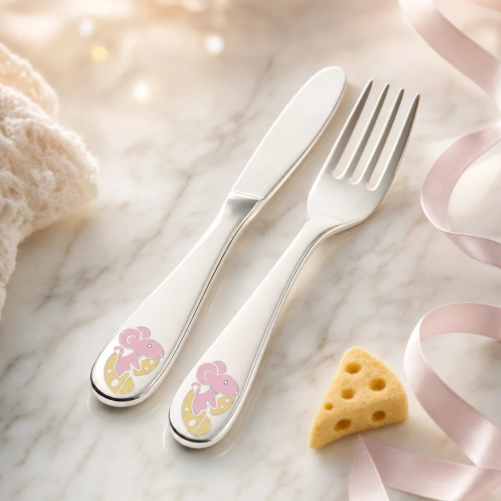 Silber-Kinderbesteck 925 mit Maus-Käse-Emaille-Motiv Nahaufnahme auf hellem Marmor mit rosa Seidenband und Filz-Käse — Detail-Lifestyle