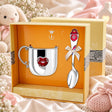 Baby-Geschenkset aus 925 Silber mit roter Emaille — Herz-Tasse und Babylöffel in gelber Geschenkbox, Lifestyle-Aufnahme, Geschenk zur Geburt