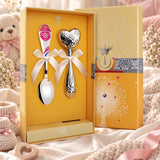 Baby-Geschenkset aus 925 Silber — Babylöffel und Rassel mit Herz-Motiv in gelber Geschenkbox, Lifestyle-Aufnahme, Geschenk zur Geburt eines Mädchens