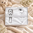 Baby Geschenkset 925 Silber Sitzender Teddy, Stielrassel und Babylöffel in weißer Zaramella-Box, Lifestyle-Aufnahme mit Plüschbär und Schleierkraut