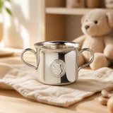 Babytasse 925 Silber Teddybär auf cremefarbener Musselin-Decke im Kinderzimmer, Plüsch-Teddybär im Hintergrund — Lifestyle