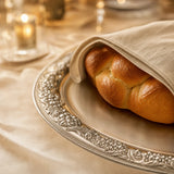 Ziselierter Rand der Challah-Platte aus 925 Silber mit Challah unter einem Leinentuch — Lifestyle