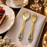 Dessertbesteck Sternzeichen Fische aus 925 Silber vergoldet neben einem Dessertteller mit Torte – vergoldetes Fische-Bild im Löffel, Symbol auf der Gabel