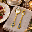 Dessertbesteck Sternzeichen Stier aus 925 Silber vergoldet neben einem Dessertteller mit Torte – vergoldetes Stier-Bild im Löffel, Symbol auf der Gabel