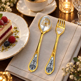 Dessertbesteck Sternzeichen Wassermann aus 925 Silber vergoldet neben einem Dessertteller mit Torte – vergoldetes Wassermann-Bild im Löffel, Symbol auf der Gabel