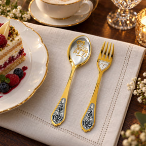 Dessertbesteck Sternzeichen Widder aus 925 Silber vergoldet neben einem Dessertteller mit Torte – vergoldetes Widder-Bild im Löffel, Symbol auf der Gabel