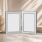 Doppel-Bilderrahmen aus 925 Silber für zwei Fotos im Format 13 × 18 cm in elegantem Studio-Lifestyle-Ambiente.