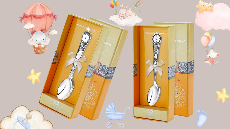 Zwei gravierbare Geburtslöffel aus 925er Silber in Geschenkboxen, dekoriert mit Baby-Motiven wie Ballon, Sternen, Schnuller und Häschen – ideal als Tauf- oder Geburtsgeschenk.
