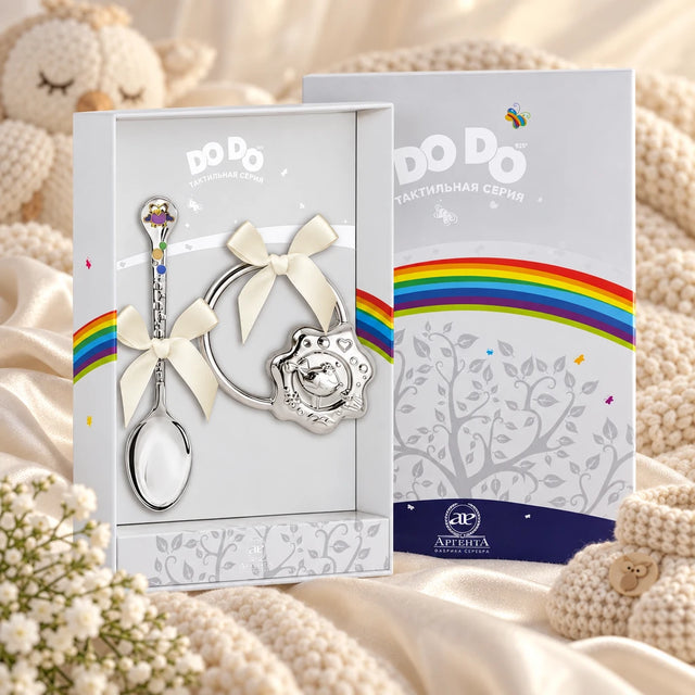 Geschenkset DoDo 925 Silber — Eulchen-Löffel & Vogel-Rassel in der Original-Geschenkbox — Lifestyle-Aufnahme auf cremefarbenem Satin mit Plüschtier und Schleierkraut, Geschenk zur Geburt