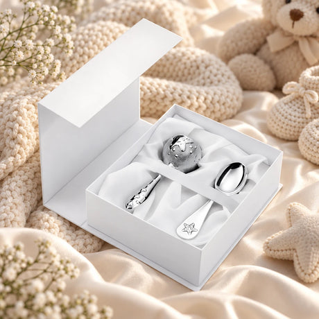 Geschenkset Zaramella 925 Silber Stern — Babylöffel + Kugelrassel in der Original-Geschenkbox — Lifestyle-Aufnahme auf cremefarbenem Satin mit Plüschtier und Schleierkraut, Geschenk zur Geburt