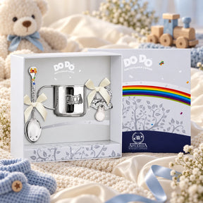 Geschenkset DoDo 925 Silber Dampflok — Schnuller, Becher, Löffel in der Original-Geschenkbox — Lifestyle-Aufnahme auf cremefarbenem Satin mit Plüschtier und Schleierkraut, Geschenk zur Geburt