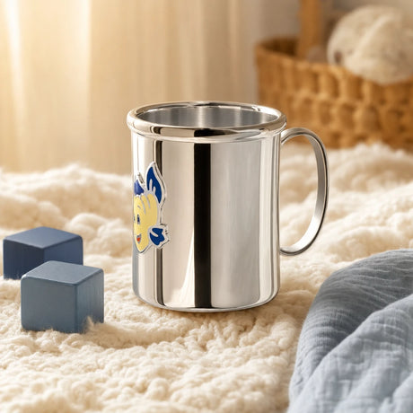 Kinderbecher aus 925 Silber mit Fisch-Motiv auf einer cremeweißen Strickdecke im Kinderzimmer — Lifestyle