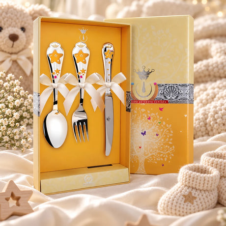 Kinderbesteck Sterne 925 Silber — Emaille gelb-rot 3-tlg in der Original-Geschenkbox — Lifestyle-Aufnahme auf cremefarbenem Satin mit Plüschtier und Schleierkraut, Geschenk zur Geburt