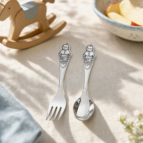 Kinderbesteck Junge 925 Silber mit Schaukelpferd-Relief auf hellem Leinentuch am Familientisch — Lifestyle