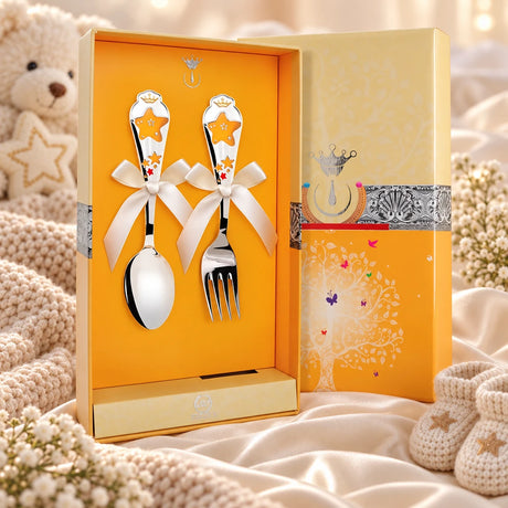 Kinderbesteck Sterne 925 Silber — Emaille gelb-rot 2-tlg in der Original-Geschenkbox — Lifestyle-Aufnahme auf cremefarbenem Satin mit Plüschtier und Schleierkraut, Geschenk zur Geburt