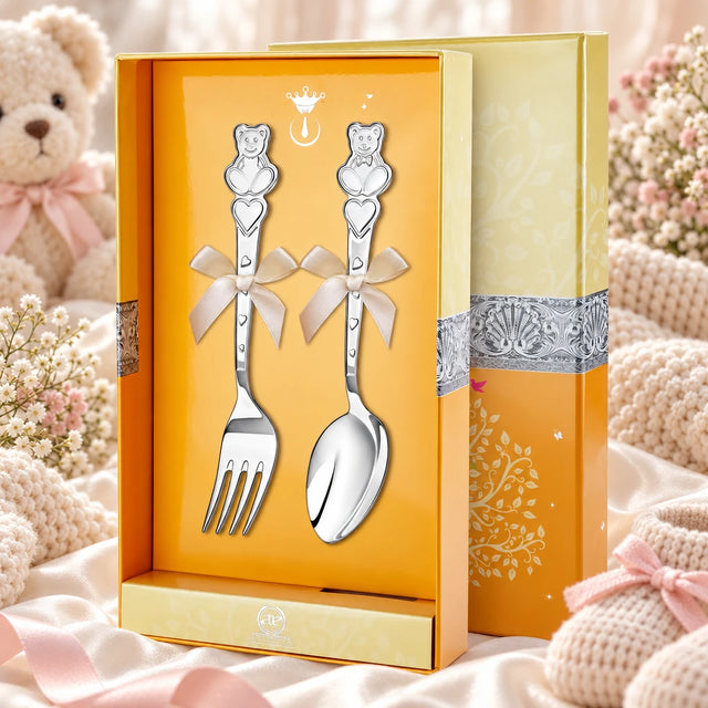 Kinderbesteck Teddybär 925 Silber Pur — Herz-Edition 2-tlg in der Original-Geschenkbox — Lifestyle-Aufnahme auf cremefarbenem Satin mit Plüschtier und Schleierkraut, Geschenk zur Geburt