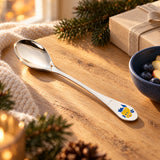 Kinderlöffel 925 Silber mit Emaille-Fisch auf Eichenholz am Fenster, Tannenzweige und Geschenkschachtel im warmen Vorweihnachtslicht — Lifestyle
