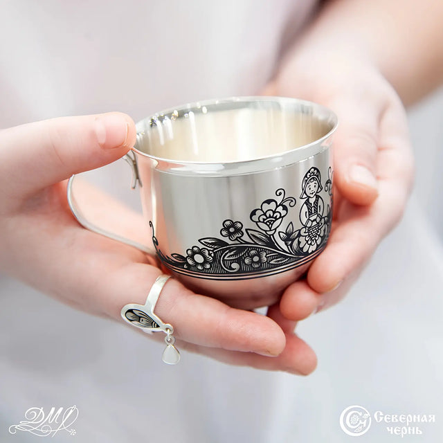 Kindertasse 925 Silber Niello — Kinderhände halten Tasse mit Niello-Mädchenmotiv, Lifestyle-Aufnahme, 125 ml, Taufgeschenk