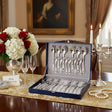Silberbesteck Set 24-teilig 925 Sterling Silber in Geschenkbox auf festlichem Tisch mit Rosen - Jubiläumsgeschenk.