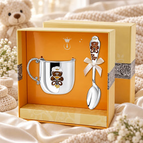 Geschenkset Teddybär 925 Silber – Kinderbecher & Löffel gravierbar in der Original-Geschenkbox — Lifestyle-Aufnahme auf cremefarbenem Satin mit Plüschtier und Schleierkraut, Geschenk zur Geburt
