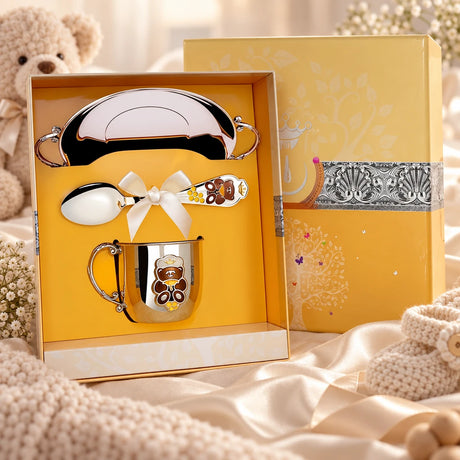 Geschenkset Teddybär 925 Silber Emaille — Tasse, Löffel & Teller in der Original-Geschenkbox — Lifestyle-Aufnahme auf cremefarbenem Satin mit Plüschtier und Schleierkraut, Geschenk zur Geburt