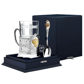 Teeglashalter-Set Doppeladler 925 Silber ArgentA im Premium-Etui — Podstakannik mit vergoldetem russischen Doppeladler-Wappen im zentralen Medaillon, klassizistische Säulenstruktur, Karo-Kristallglas und Teelöffel Edinstvo mit vergoldetem Wappen-Stielende, samtgefüttertes Geschenketui in Marineblau