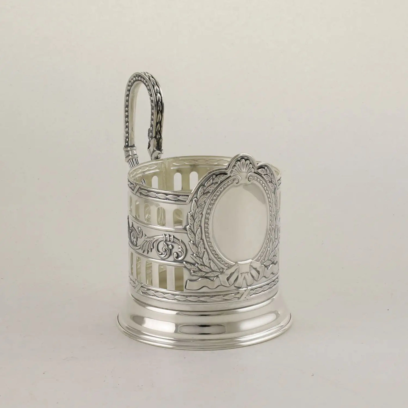 Podstakannik Patron 925 Silber Seitenansicht — klassizistischer Bügelhenkel mit Lorbeerblatt-Verzierung und Perlrand, glockenförmiger Standfuß, antik patinierte Akanthus-Bordüren, gleiche Bauform wie die anderen Wappen-Sets der ArgentA-Linie Classic