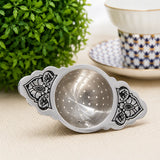 Teesieb 925 Silber mit Niello-Blumenornament — neben blau gemusterter Teetasse vor grüner Pflanze